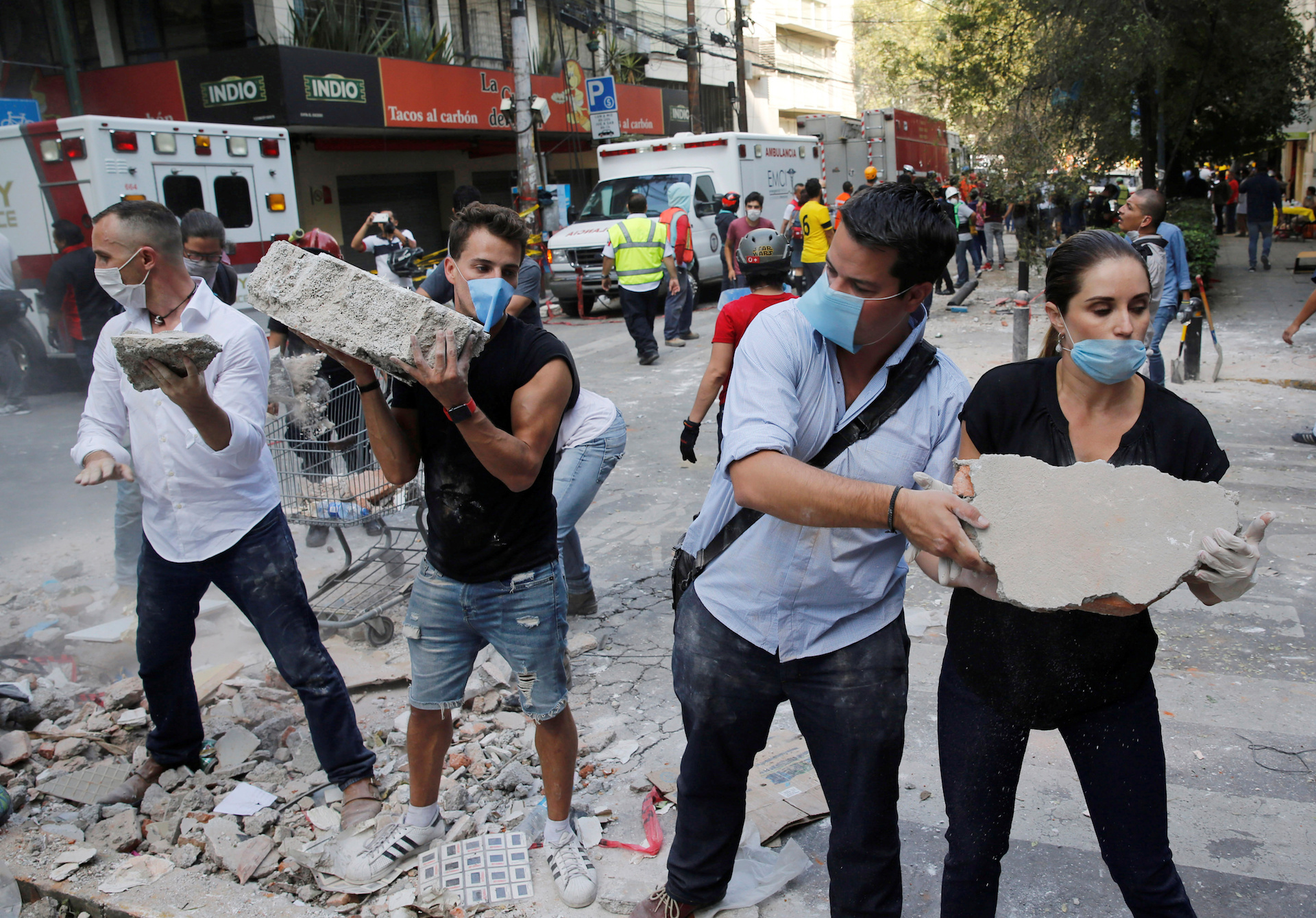 People remove debris outside at a collapsed building after an earthquake in Mexico City